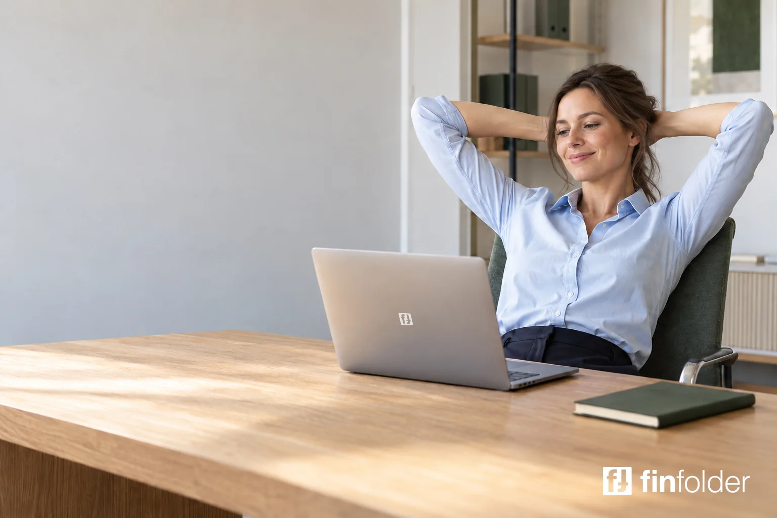 A relaxed business owner leans back and looks at her laptop